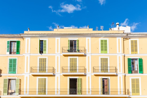Fachada de edificio de apartamentos con coloridas persianas en Mallorca.