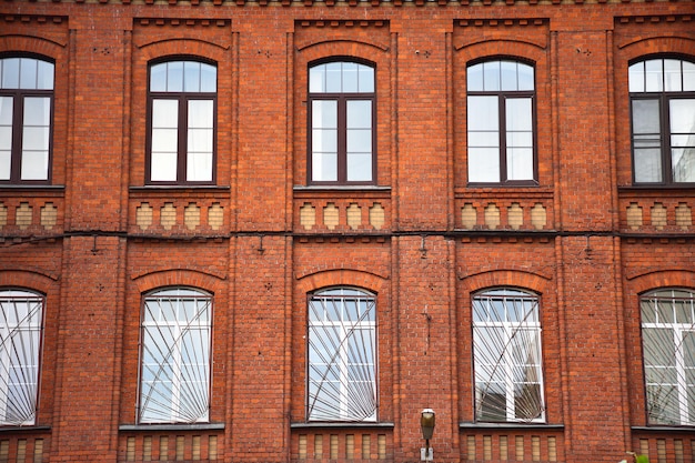 La fachada del edificio de ladrillos rojos con ventanas.