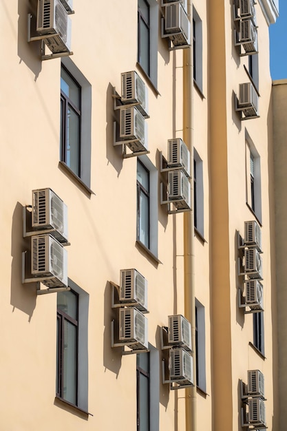 Fachada de un edificio con muchos acondicionadores de aire en las ventanas del país cálido del sur