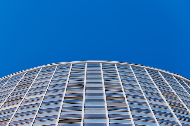 Fachada de edificio de varios pisos, espacio de copia. Ritmo en fotografía. Nueva fachada de varios pisos, ventanas y bloque de pisos, de cerca. Apartamentos modernos en edificio alto