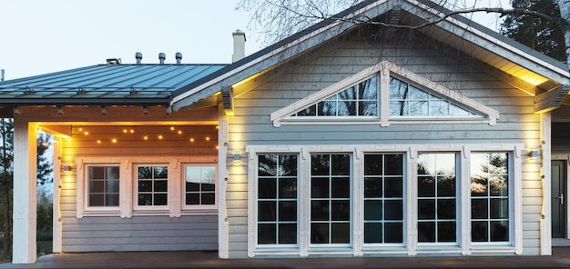 Fachada de una hermosa casa de madera Iluminación de moda en la fachada Letonia