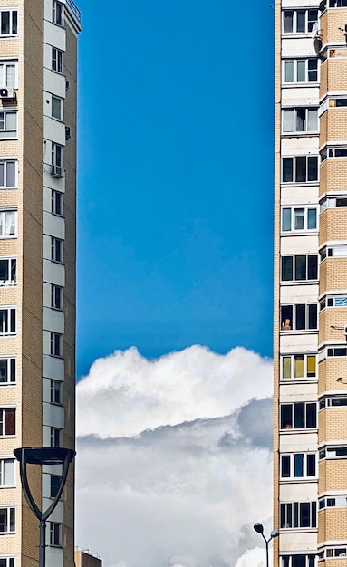 Fachada de un moderno edificio de apartamentos contra un cielo azul con nubes