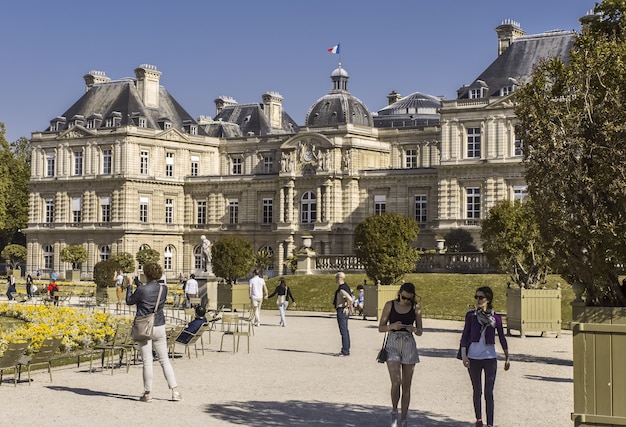 Fachada del palacio de Luxemburgo en París, día soleado, árbol en la bañera y chicas elegantes Francia