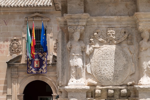 Fachada del palacio de la universidad internacional con banderas y fuente renacentista Baeza