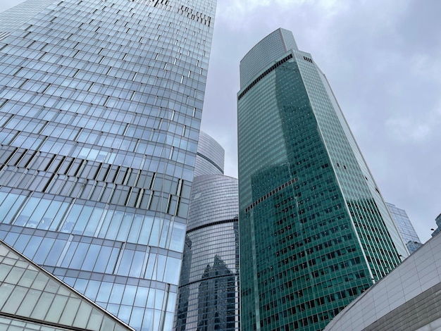 Fachada de un rascacielos moderno con paredes de cristal Desde abajo de un rascacielos alto contemporáneo con paredes de cristal contra el cielo nublado en el centro