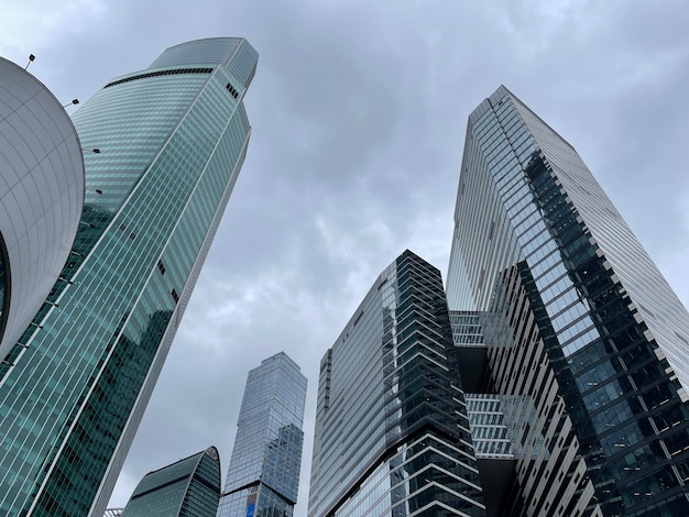 Fachada de un rascacielos moderno con paredes de cristal Desde abajo de un rascacielos alto contemporáneo con paredes de cristal contra el cielo nublado en el centro