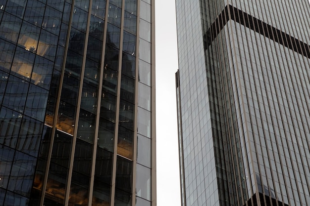 Fachada de un rascacielos moderno con paredes de cristal Desde abajo de un rascacielos alto contemporáneo con paredes de cristal contra el cielo nublado en el centro