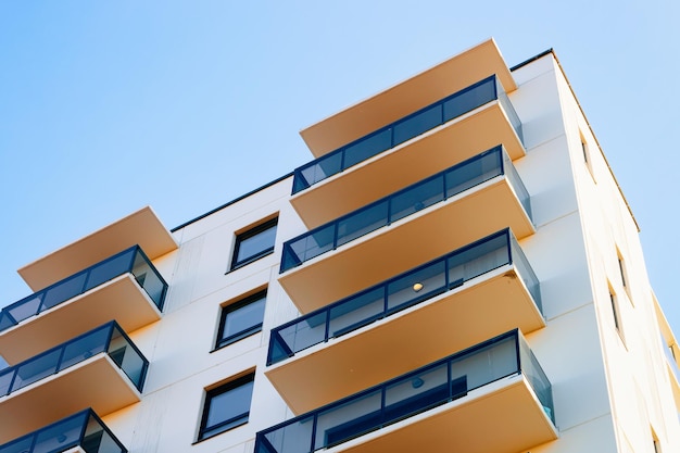 Fachada residencial do apartamento e um lugar em branco para o espaço da cópia. Céu azul ao fundo.