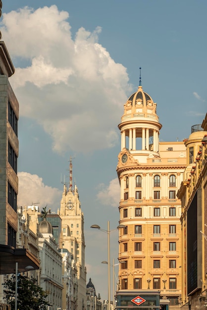 Foto fachadas y un cielo con hermosas nubes en la plaza de callao de madrid junto a la calle principal