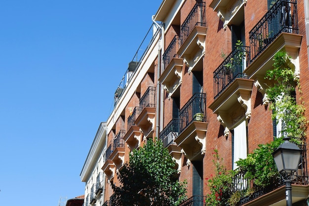 Fachadas de edificios clásicos con vegetación vívida y balcones antiguos en el centro de Madrid España Arquitectura antigua Vida antigua