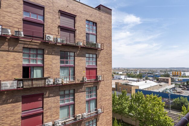 Fachadas de edificios residenciales urbanos junto a un polígono industrial en un día soleado