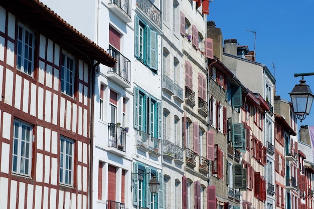 Fachadas vintage coloridas de casas típicas bascas francesas com persianas e janelas de cores desbotadas no centro da cidade baiana de Bayonne, Espanha