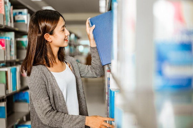 Faculdade de estudantes asiáticos escolhendo um livro para ler antes do exame na bibliotecaEducation Learning Student Campus University Lifestyle concept