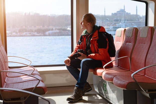 Fähre über den bosporus in istanbul, türkei. innenraum eines schiffes mit mannpassagier, roten sitzen und meerblick.