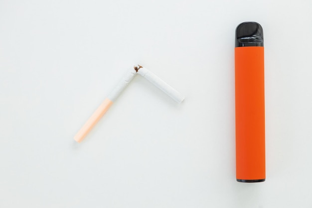Färben Sie elektronische Einwegzigaretten und normale Nikotinzigaretten auf einem weißen Hintergrund. Wahl des modernen Raucherkonzepts