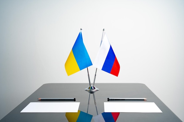Fahnen Russlands und der Ukraine am Verhandlungstisch