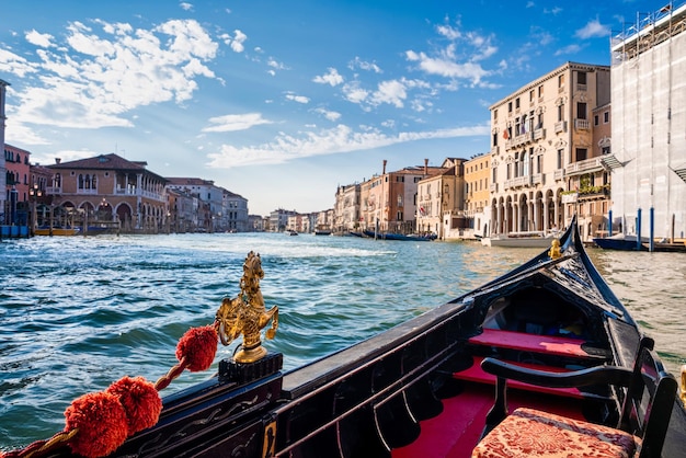 Fahren Sie mit einer traditionellen Gondel durch die engen Kanäle in Venedig, Italien. Retro-Vintage-getönten Instagram-Stil-Grunge-Filter und Lens Flare-Sonnenlicht-Effekt.