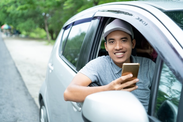 Fahrer des jungen Mannes verwenden Smartphone-Blick auf Kamera