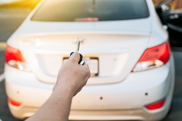 Fahrerhände, die die Autoschlüssel zeigen Fahrerhände, die die Schlüssel außerhalb des Fahrzeugs zeigen Konzept der Fahrzeugvermietung Nahaufnahme des Fahrers außerhalb des Autos, der die Schlüssel hält