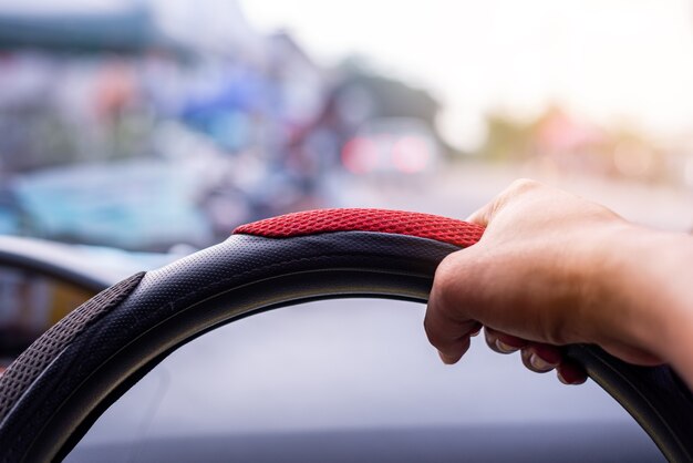 Fahrkonzept, Hand, die ein Auto auf der Straße fährt, verwischte Hintergrund