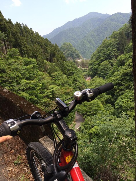 Foto fahrrad, das auf dem land gegen berge geparkt ist