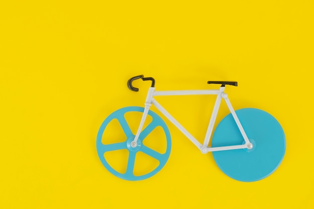 Fahrrad mit blauen Rädern auf einem hellen Gelb