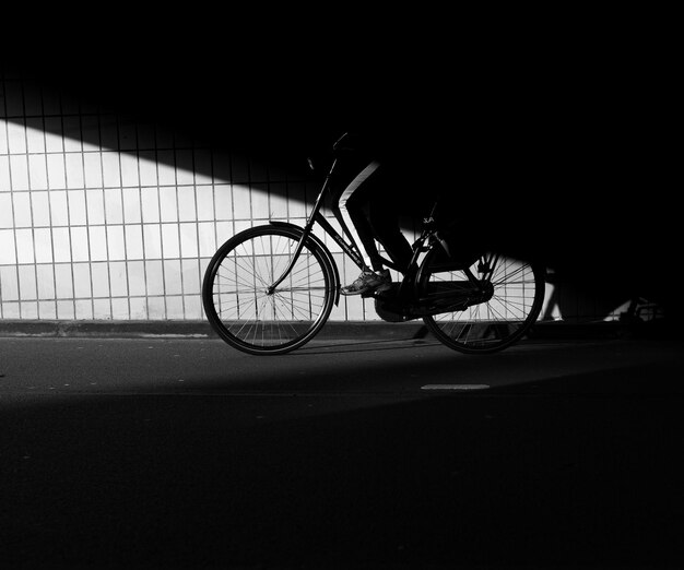 Fahrrad ruht gegen eine dunkle Stadtmauer mit Schatten