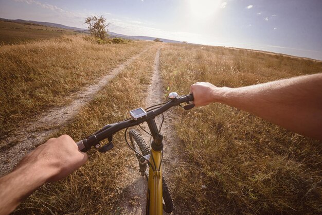 Fahrradlenker mit See und Sonnenschein im Hintergrund