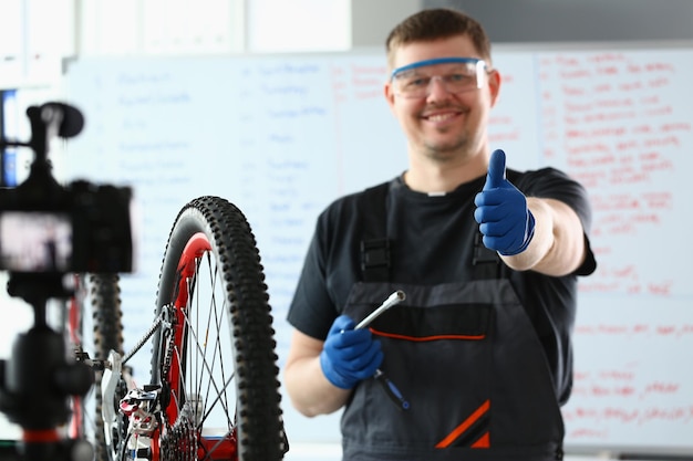 Fahrradmechaniker in der Werkstatt, die Daumen hochhält