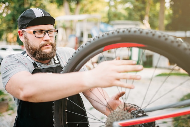 Fahrradreparaturmann arbeitet mit Fahrradrad