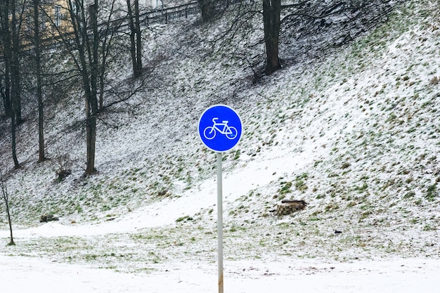 Fahrradschild im Winter. Landschaftsschnee auf dem Gras