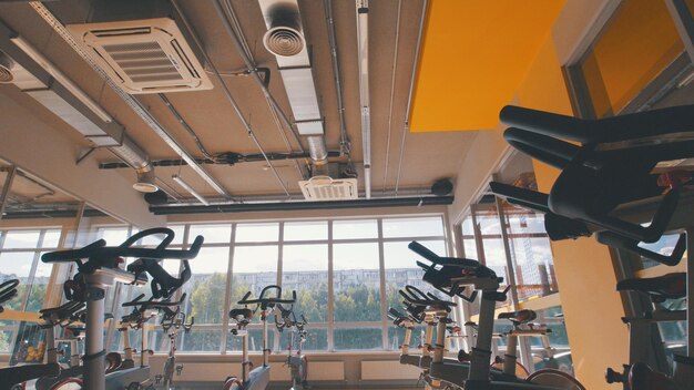 Fahrradsimulatoren in der Turnhalle, Innenraum des modernen Fitnessclubs, Hintergrund