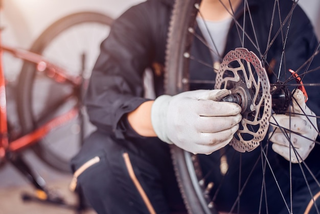 Foto fahrradwartung der fahrer baut die fahrradteile zusammen nahaufnahme