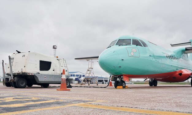 Fahrzeug in der Nähe von Turboprop-Flugzeugen, die tagsüber auf der Landebahn geparkt sind