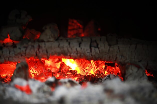 Faíscas em brasa voam de um grande incêndio. Carvões em brasa, partículas em chamas voando contra um fundo preto.