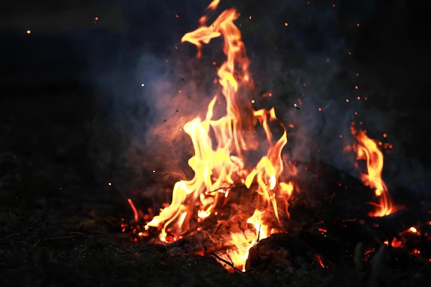 Faíscas em brasa voam de um grande incêndio. Carvões em brasa, partículas em chamas voando contra um fundo preto.