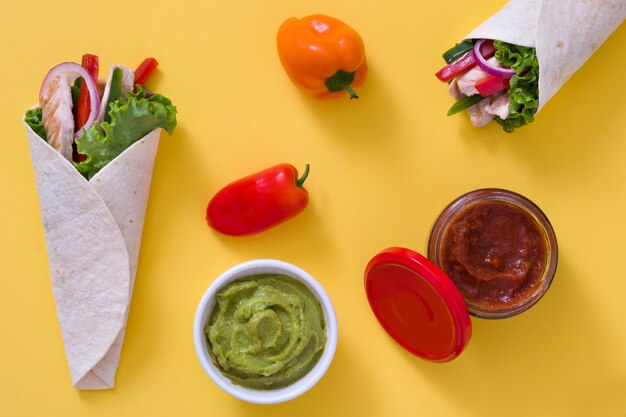 Fajita de frango mexicano com pimentão alface e cebola na mesa amarela