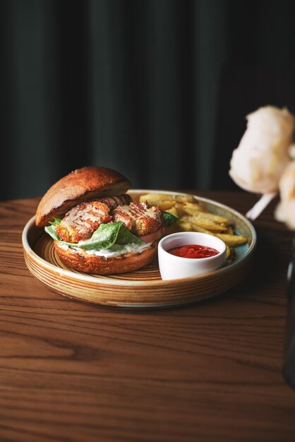 Falafel-Burger mit Salat Tomaten Zwiebel Pommes Frites würzig duftende Sauce auf einem Holztisch Vegetarisches Essen lecker und nahrhaft