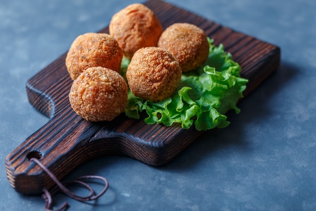 Falafel se encuentra sobre una tabla para cortar madera.