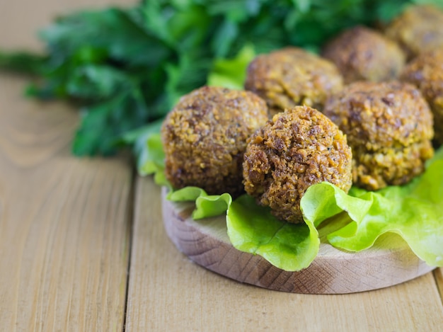 Falafel feito na hora clássico em uma folha de salada em uma placa de corte