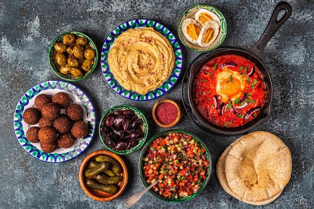 Falafel, homus, shakshuka, salada israelense - pratos tradicionais da culinária israelense. vista do topo.