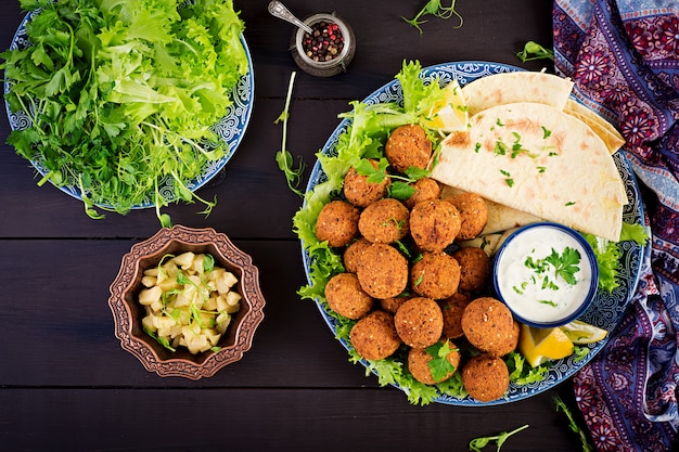 Falafel, Hummus und Pita. Nahöstliche oder arabische Gerichte auf einem dunklen Tisch