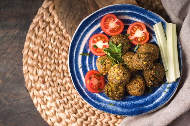 Falafel con tomates en la vista superior de la placa de cerámica