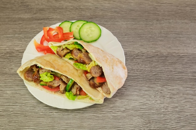 Falafel y verduras frescas en pan pita en madera