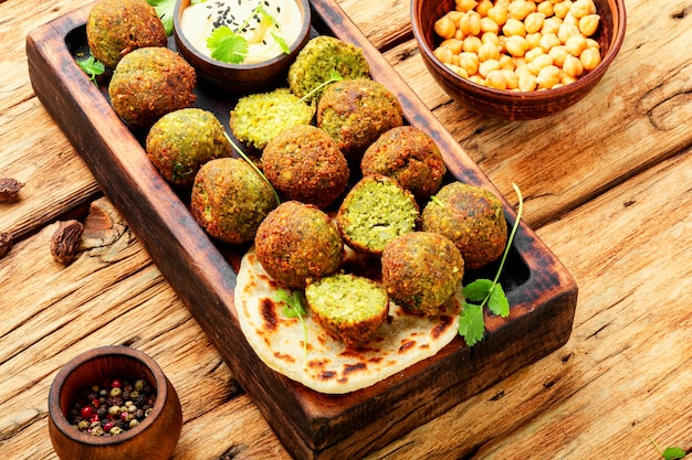 Foto falafelbällchen auf einem holzbrett. arabischer snack falafel