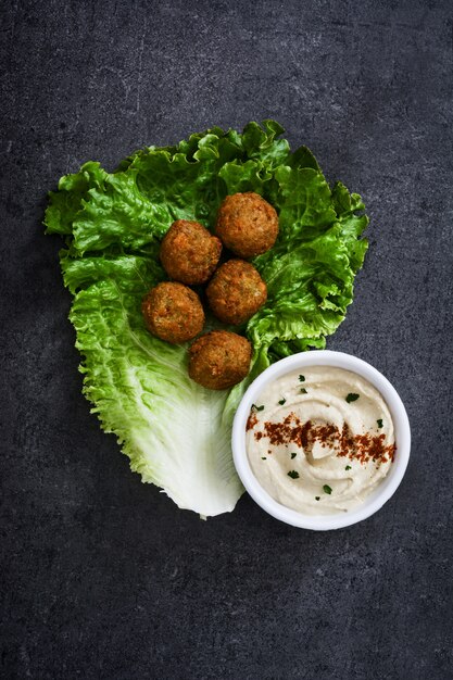 Foto falafels vegetarianos com alface e homus no preto