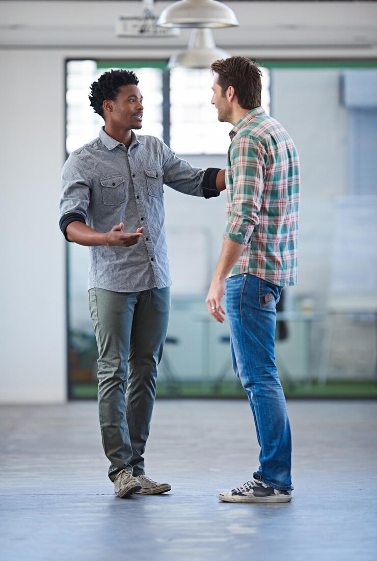 Foto falar em equipe e homens de negócios no escritório com apoio para colaboração parceria ou conselho discussão de planejamento de eventos e funcionários com solidariedade no espaço de trabalho para conversa confiança ou unidade