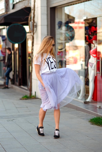 Falda de línea A de color lavanda La chica es muy dinámica posando en la calle la falda se está desarrollando Primer plano de mujeres disfrutando de las compras