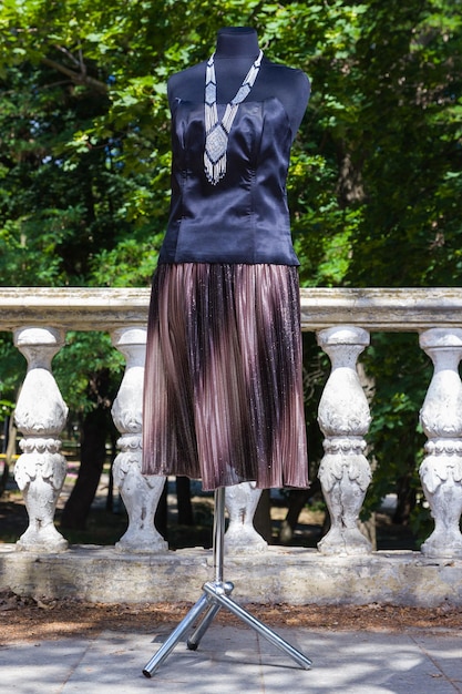 Falda marrón y corsé negro sobre maniquí Falda y corsé con modulaciones sobre fondo natural Tejido con lentejuelas para confección de mujer Sastrería individual