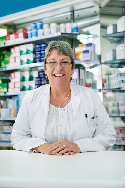 Fale comigo para todas as suas dúvidas relacionadas à saúde Retrato de uma mulher madura feliz trabalhando em uma farmácia